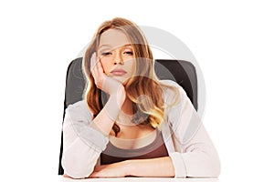 Young worried woman sitting at the desk