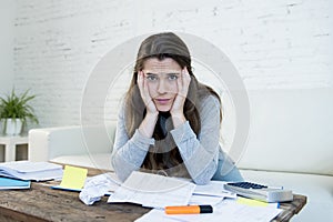 Young worried woman suffering stress doing domestic accounting paperwork bills