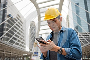 Young foreman engineer worker using smartphone