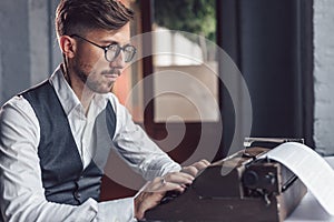 Young writer typing on a retro typewriter