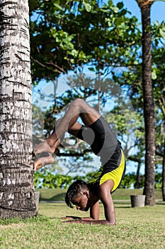 Young yoga man practitioners doing yoga on nature. Asian indian yogis man on the grass in the park. Bali island.