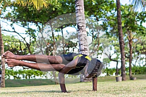 Young yoga man practitioners doing yoga on nature. Asian indian yogis man on the grass in the park. Bali island.