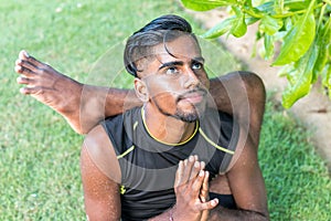 Young yoga man practitioners doing yoga on nature. Asian indian yogis man on the grass in the park. Bali island.