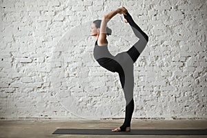 Young yogi attractive woman in Lord of the Dance pose