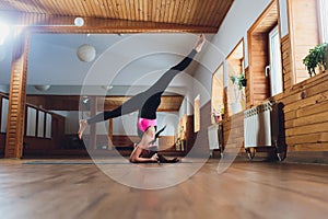 Young yogi attractive woman practicing yoga concept, standing in salamba sirsasana exercise, headstand pose, working out