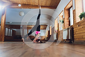 Young yogi attractive woman practicing yoga concept, standing in salamba sirsasana exercise, headstand pose, working out