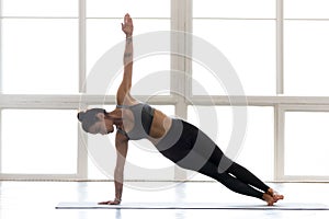 Young yogi attractive woman practicing yoga, doing Vasisthasana