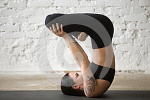 Young yogi attractive woman in Shoulder Stand pose, white backgr