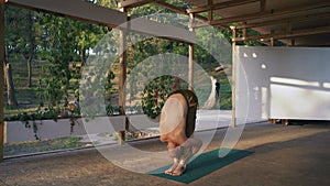 Young Yogi Performs Suryanamaskar Practice on Wooden Pomo in Rano City Park In the morning