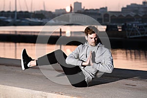 Young yogi rests his hands in a Namaste greeting position while freeing his mind from worries