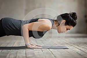 Young yogi woman doing Push ups or press ups