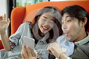 Younger asian man and woman happiness emotion when looking on sm