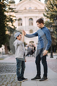 Younger brother give five to older brothe in the city