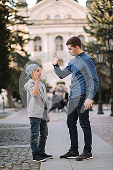 Younger brother give five to older brothe in the city