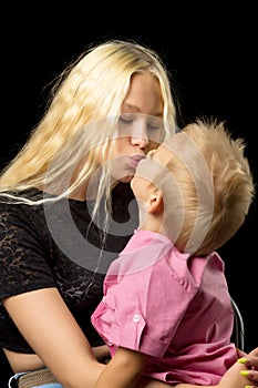 Younger brother with older sister in the studio on a black background.