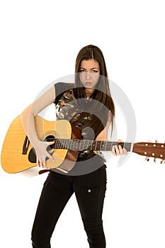 Younger female model playing guitar serious facial expression