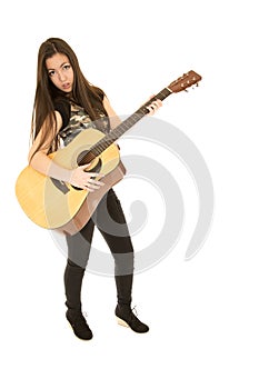 Younger female model standing playing her acoustic guitar