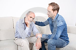 Younger man comforting older man