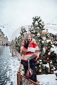 Younggirl on the red Square through winter holiday in Moscow, stylish and beautiful posing near to Christmas tree