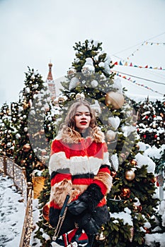 Younggirl on the red Square through winter holiday in Moscow, stylish and beautiful posing near to Christmas tree