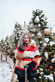 Younggirl on the red Square through winter holiday in Moscow, stylish and beautiful posing near to Christmas tree