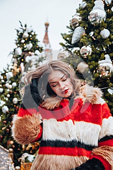 Younggirl on the red Square through winter holiday in Moscow, stylish and beautiful posing near to Christmas tree