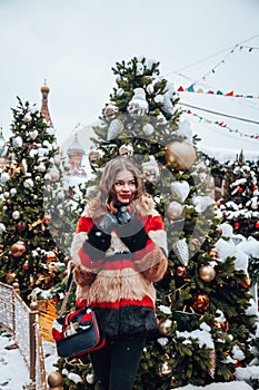 Younggirl on the red Square through winter holiday in Moscow, stylish and beautiful posing near to Christmas tree