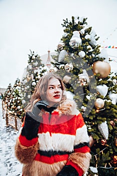 Younggirl on the red Square through winter holiday in Moscow, stylish and beautiful posing near to Christmas tree