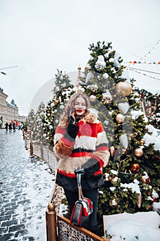 Younggirl on the red Square through winter holiday in Moscow, stylish and beautiful posing near to Christmas tree