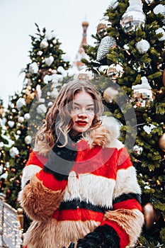 Younggirl on the red Square through winter holiday in Moscow, stylish and beautiful posing near to Christmas tree