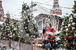 Younggirl on the red Square through winter holiday in Moscow, stylish and beautiful posing near to Christmas tree