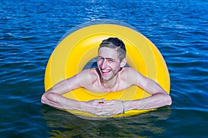 Youngman on a inflatable buoy laughing photo