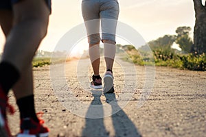 Youngs fitness woman trail running on rural road in summer