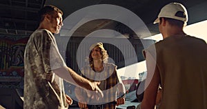 Youngster friends socializing together at skate park. Teens resting at skatepark