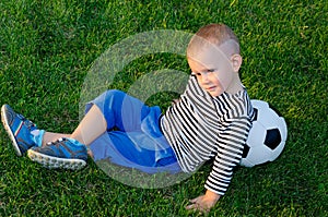 Youngster lying against his soccer ball