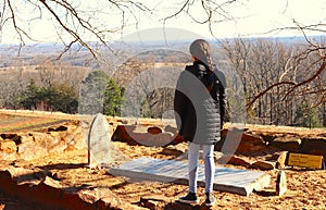 Youngster Reads Gravestone Writing on Mountaintop photo