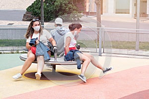 Youngsters enjoying a swing set in Covid19 time with a mask