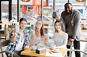 Youngsters with smartphones resting in the cafe