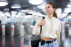 Younh female passing the turnstiles at subway station