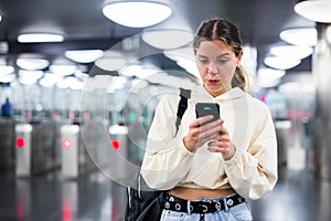 Younh female passing the turnstiles at subway station