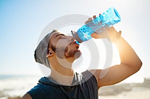 Your body cant perform at its best if youre not hydrated. a sporty young man drinking water while exercising outdoors.