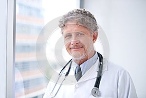 Your care is top priority. Portrait of a smiling mature doctor standing in his office.