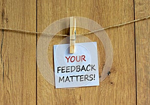 Your feedback matters symbol. White paper with text `your feedback matters`, clip on wood clothespin. Beautiful wooden backgroun