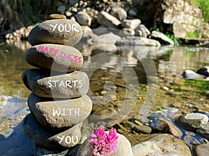 Your happiness starts with you text on stacked rocks background. Stock photo.