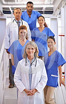 Your health is their priority. Portrait of a diverse team of medical professionals standing on a staircase in a hospital