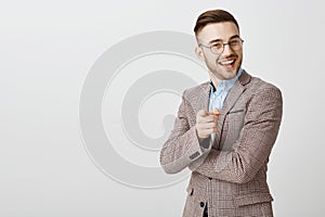 Your ideas promising. Pleased and delighted smart businessman in trendy formal jacket and glasses smiling and pointing