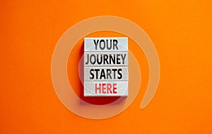 Your journey starts here symbol. Concept words Your journey starts here on wooden blocks on a beautiful orange table orange