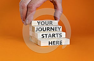 Your journey starts here symbol. Concept words Your journey starts here on wooden blocks on a beautiful orange table orange