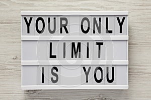 `Your only limit is you` word on modern board on a white wooden background, top view. From above, flat lay, overhead