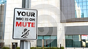 Your mic is on mute sign in a downtown city setting